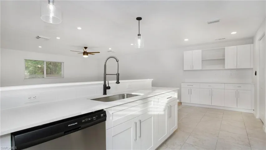 Kitchen with dishwasher, open shelves, light countertops, white cabinetry, and recessed lighting