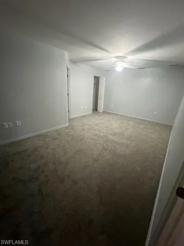 Unfurnished room featuring carpet and ceiling fan