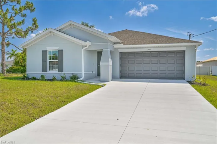 Ranch-style house featuring a front yard and a garage