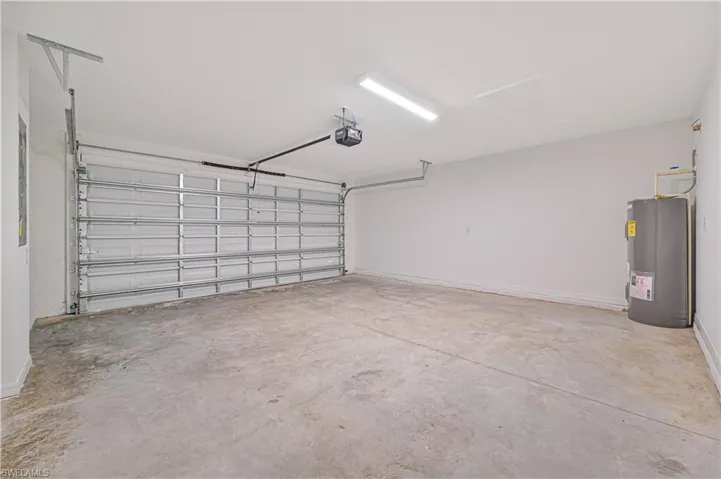 Garage featuring water heater and a garage door opener