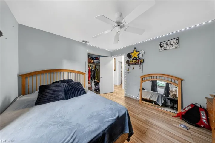 Bedroom with light wood finished floors, a ceiling fan, and a closet