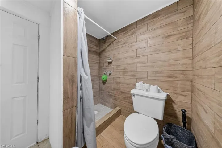 Full bathroom featuring toilet and a stall shower