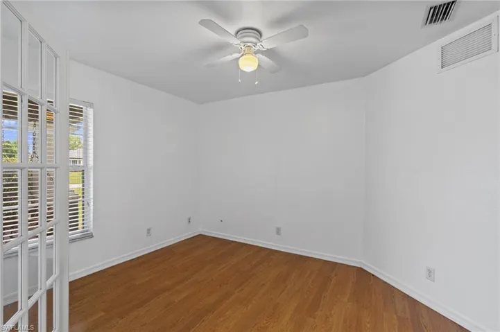 Empty room with wood finished floors and a ceiling fan