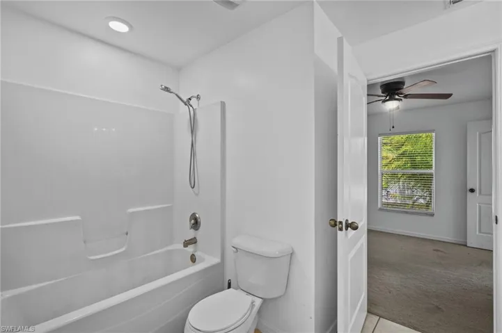 Full bath featuring ceiling fan, shower / bath combination, and tile patterned floors