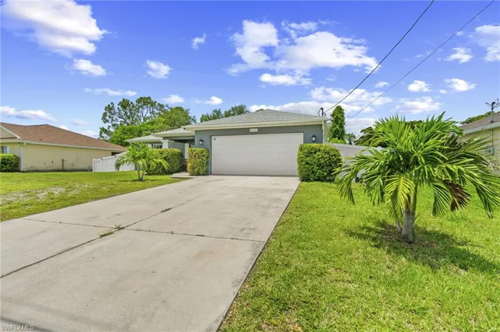 View of front facade with an attached garage, stucco siding, and driveway