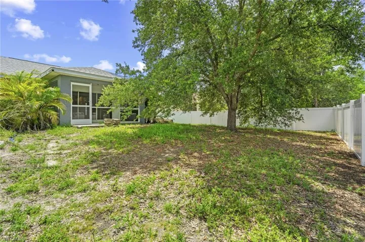 Fenced backyard featuring a sunroom