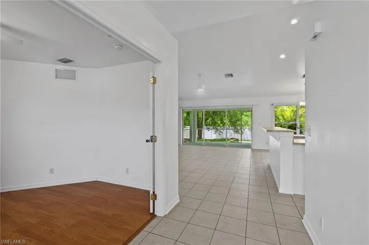 Hallway with light tile patterned floors and recessed lighting