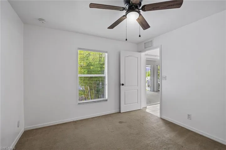Unfurnished room with carpet, a smoke detector, and ceiling fan