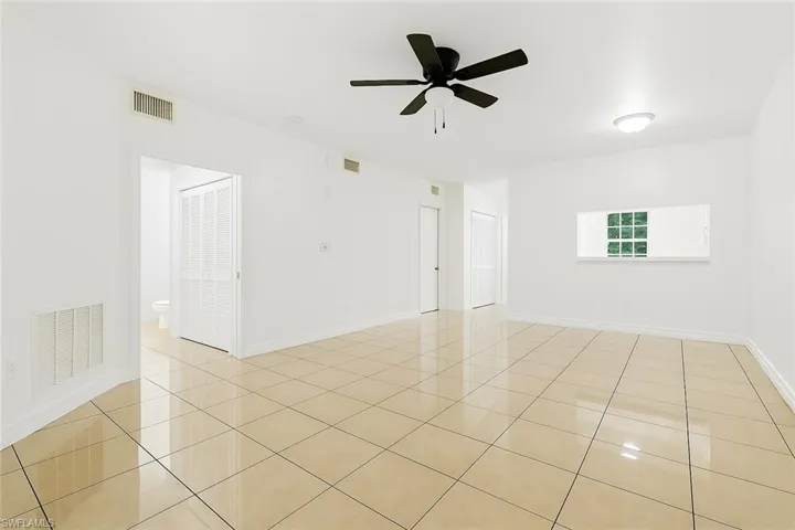 Unfurnished room with light tile patterned floors and ceiling fan