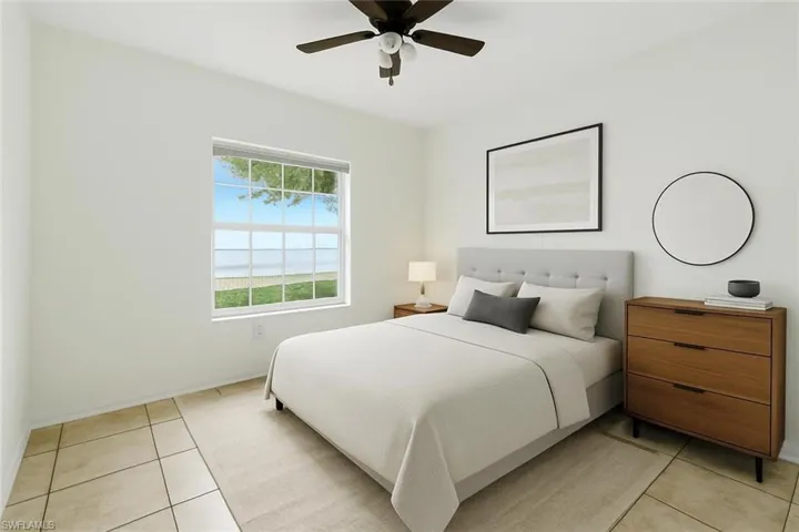 Bedroom with light tile patterned floors and a ceiling fan