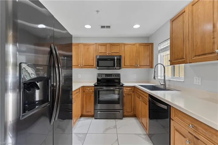 Kitchen with stainless steel appliances, wood finish cabinetry, and recessed lighting