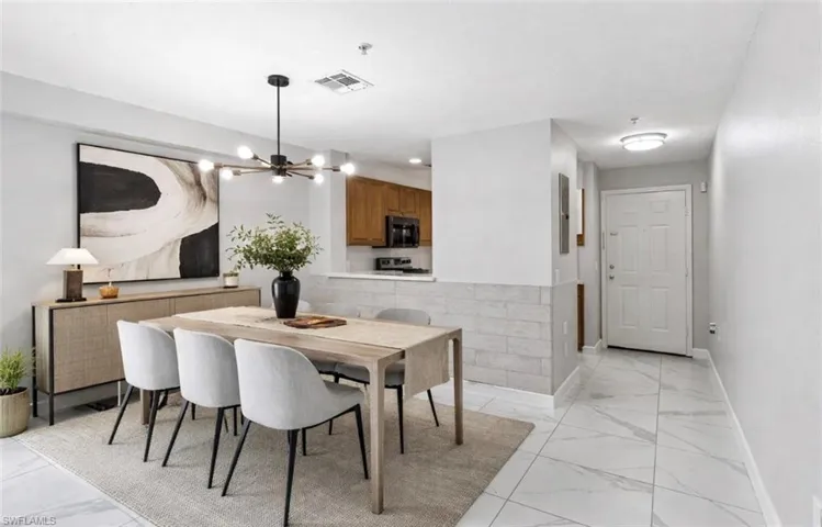 Dining room featuring light marble finish floors and hanging lights