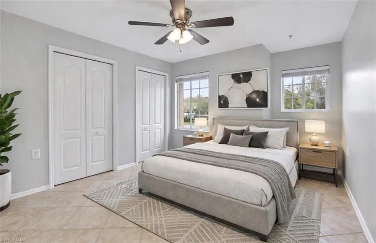 Bedroom with multiple closets, a ceiling fan, and light tile patterned flooring