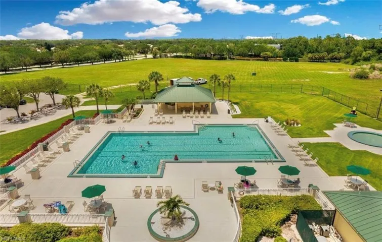 Community pool with a patio area, a gazebo, and view of wooded area