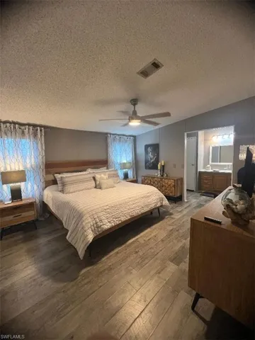 Master Bedroom featuring light wood finished floors, a textured ceiling, and a ceiling fan