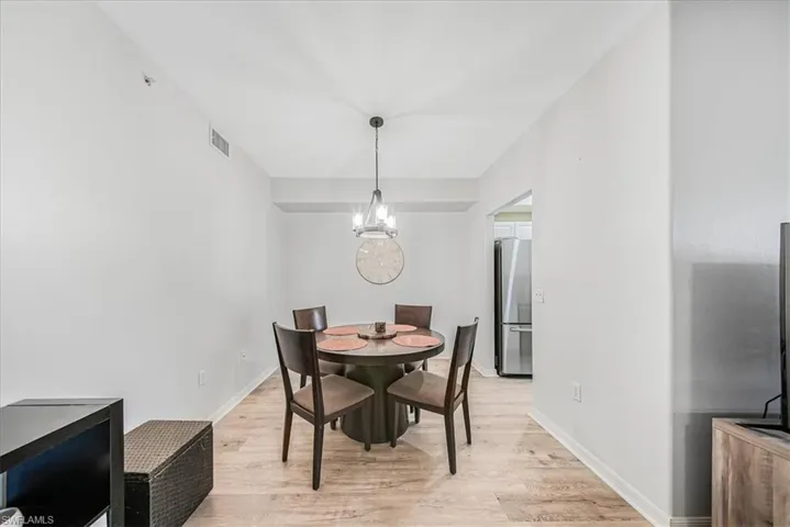 Dining area featuring light wood-type flooring and a chandelier