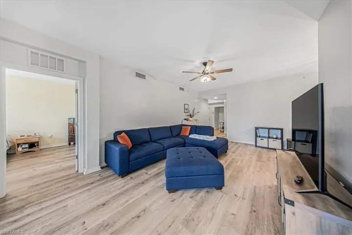 Living area with light wood-type flooring and a ceiling fan