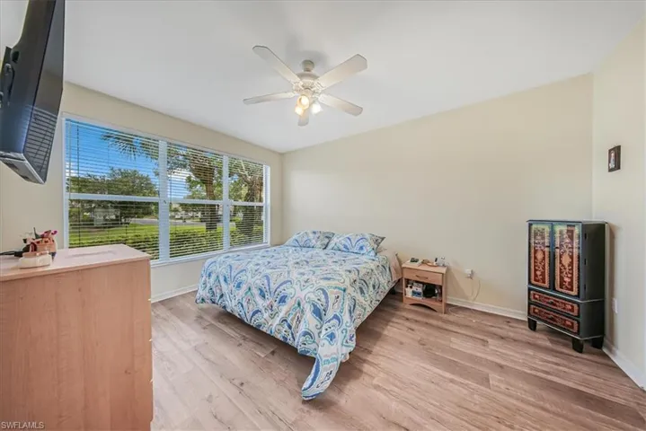 Bedroom with ceiling fan and light wood-style flooring