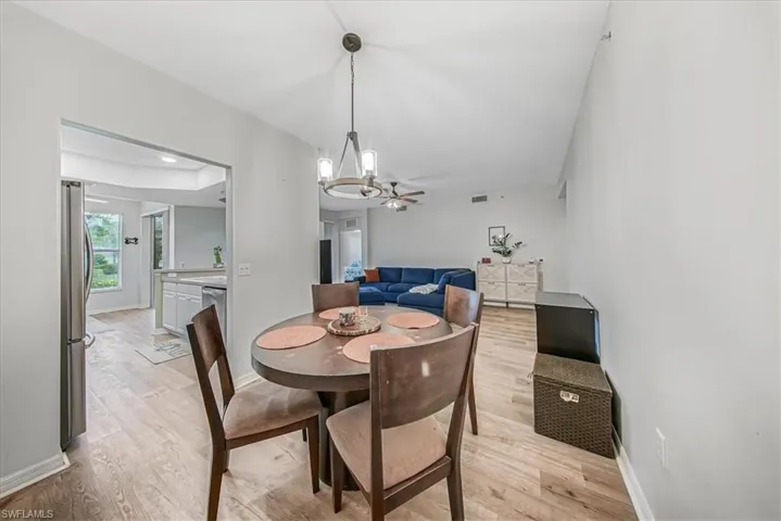 Dining area with light wood-style flooring, a chandelier, and ceiling fan