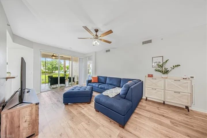 Living room with light wood-type flooring and a ceiling fan
