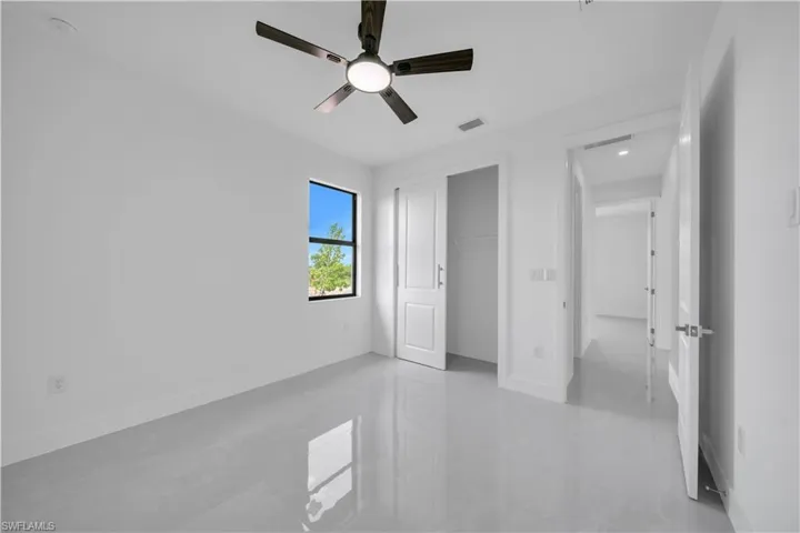 Unfurnished bedroom with concrete flooring, a closet, and ceiling fan