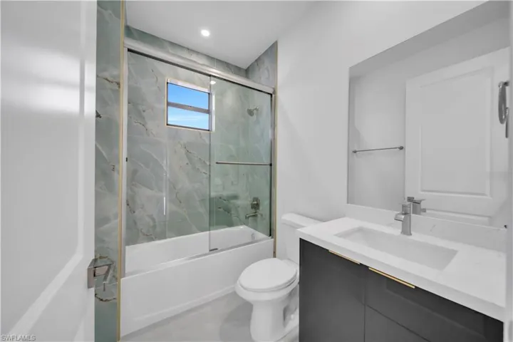 Full bath featuring vanity, shower / bath combination with glass door, and recessed lighting