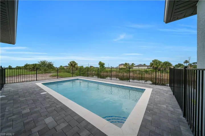 View of swimming pool with patio surround and a fenced backyard