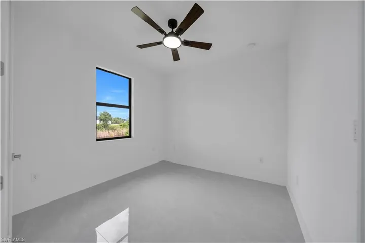 Spare room featuring finished concrete floors and ceiling fan
