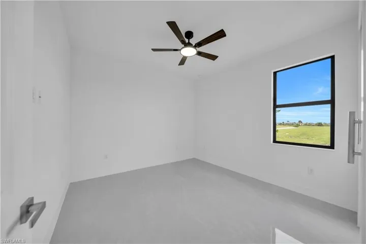 Empty room featuring ceiling fan and baseboards