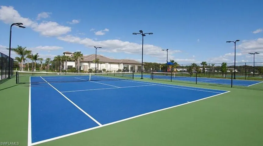 Multiple tennis courts featuring blue and green surfacing
