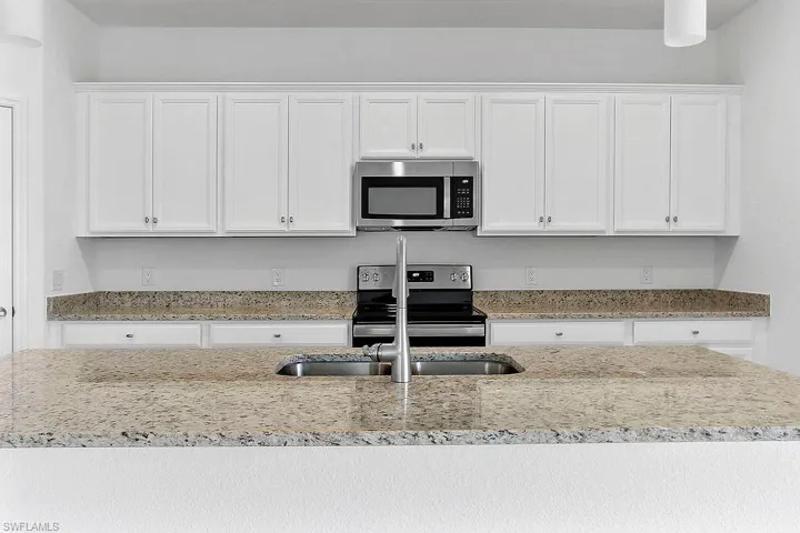 Kitchen featuring white shaker-style cabinetry, a stainless steel microwave, and a range with coordinating stainless steel appliances