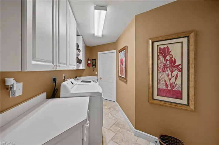 Laundry area featuring washer and new dryer and cabinets