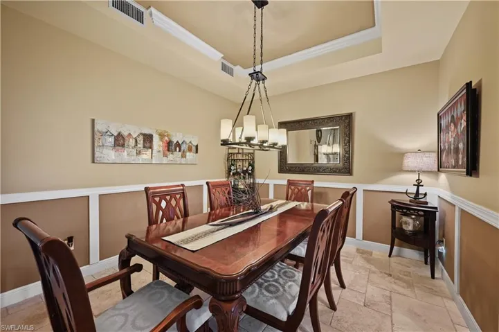 Dining area with a tray ceiling with crown molding