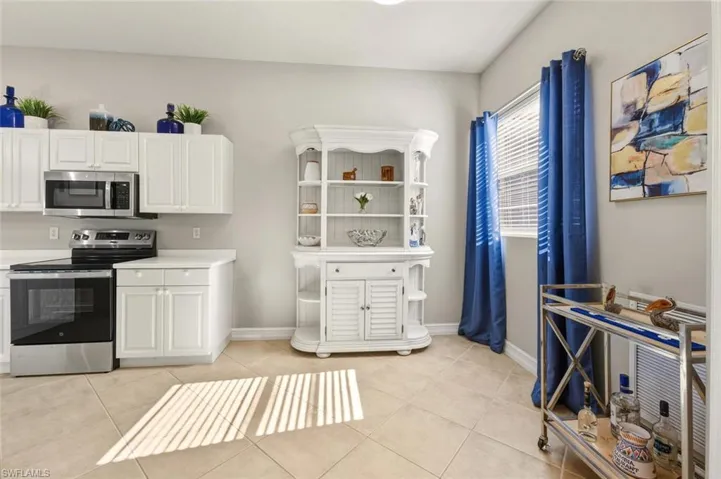 Kitchen featuring stainless steel appliances, white cabinetry, light countertops, and light tile patterned floors