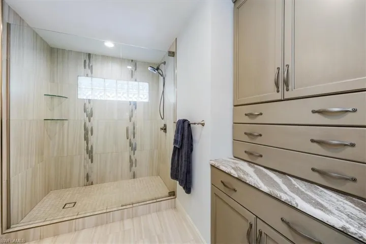 Bathroom with vanity and a tile shower
