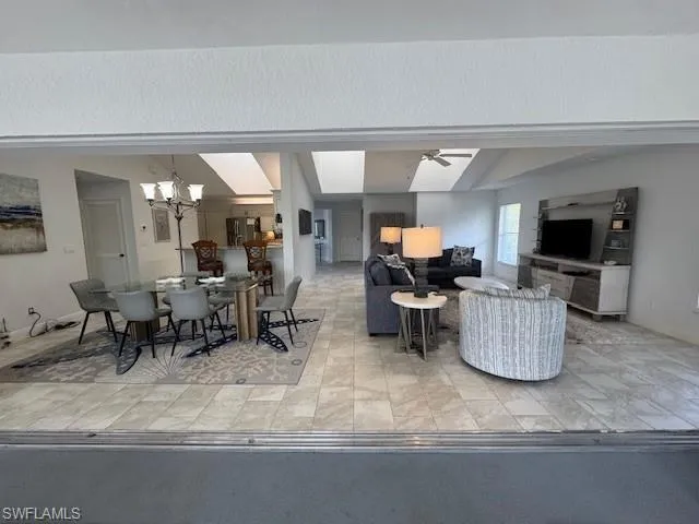 Dining room with lofted ceiling, a chandelier, and a skylight