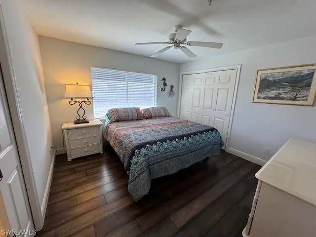Bedroom with a closet, dark wood-type flooring, and ceiling fan