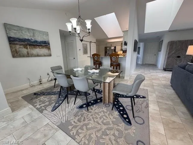 Dining room featuring vaulted ceiling and a chandelier