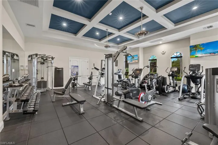 Workout area with a towering ceiling and coffered ceiling