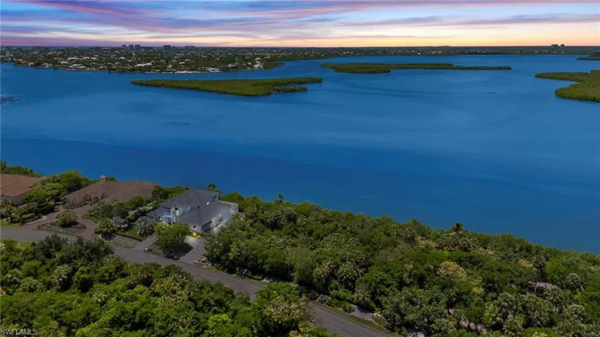 Aerial view at dusk featuring a water view