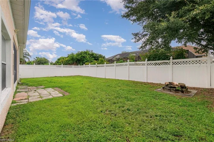 Fenced backyard featuring a fire pit