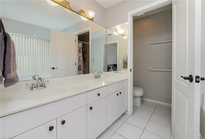 Full bathroom with double vanity and tile patterned floors
