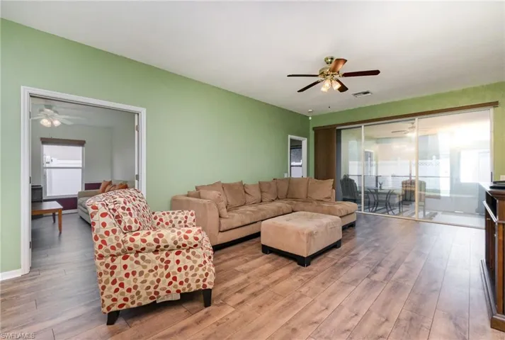 Living room featuring ceiling fan, light wood-type flooring, and plenty of natural light