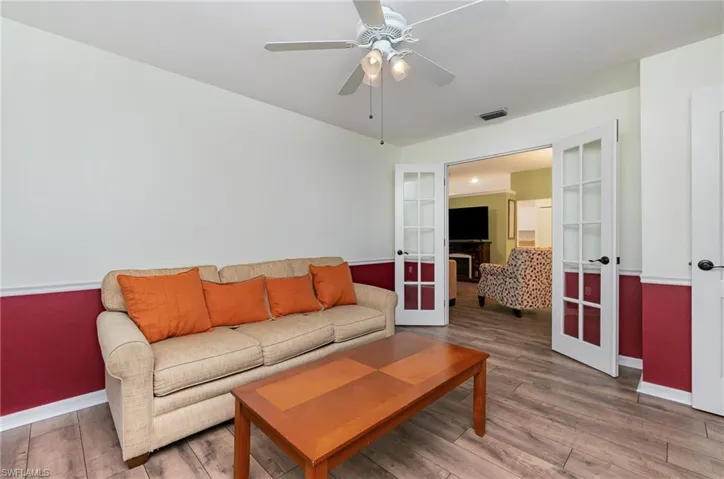 Living area featuring french doors, wood finished floors, and a ceiling fan