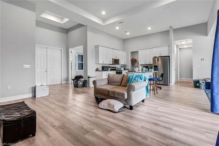Living room with a towering ceiling and light hardwood / wood-style flooring