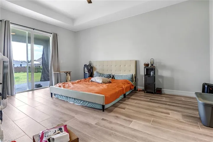 Bedroom with access to outside, light wood-type flooring, and ceiling fan