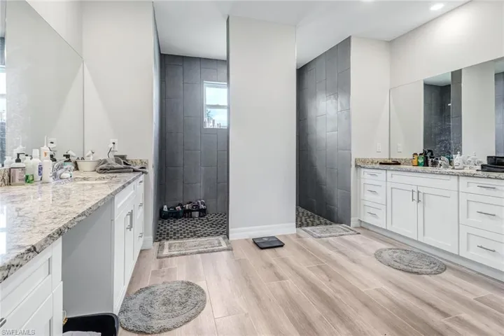 Bathroom featuring a tile shower and vanity