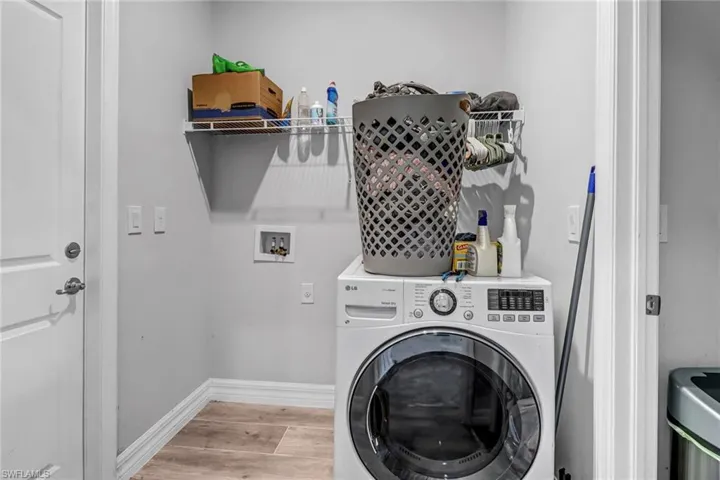 Washroom featuring light hardwood / wood-style floors and washer / clothes dryer