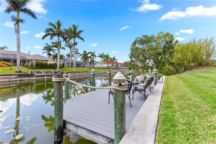 Dock with a water view, a lawn, and a residential view