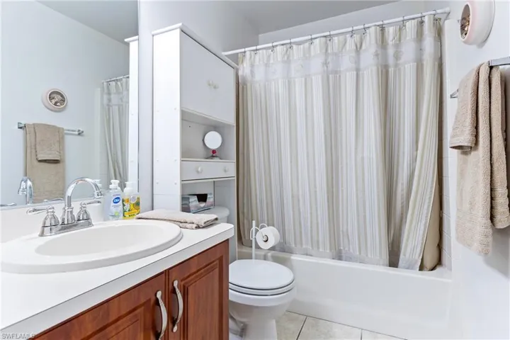 Bathroom with vanity, toilet, tile patterned flooring, and shower / bath combo